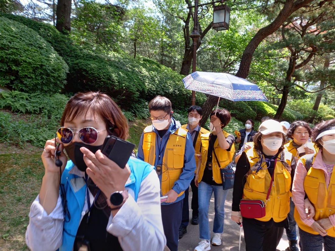 해설사를 선두로 뒤따르며 현장해설을 듣는 참가자들.jpg