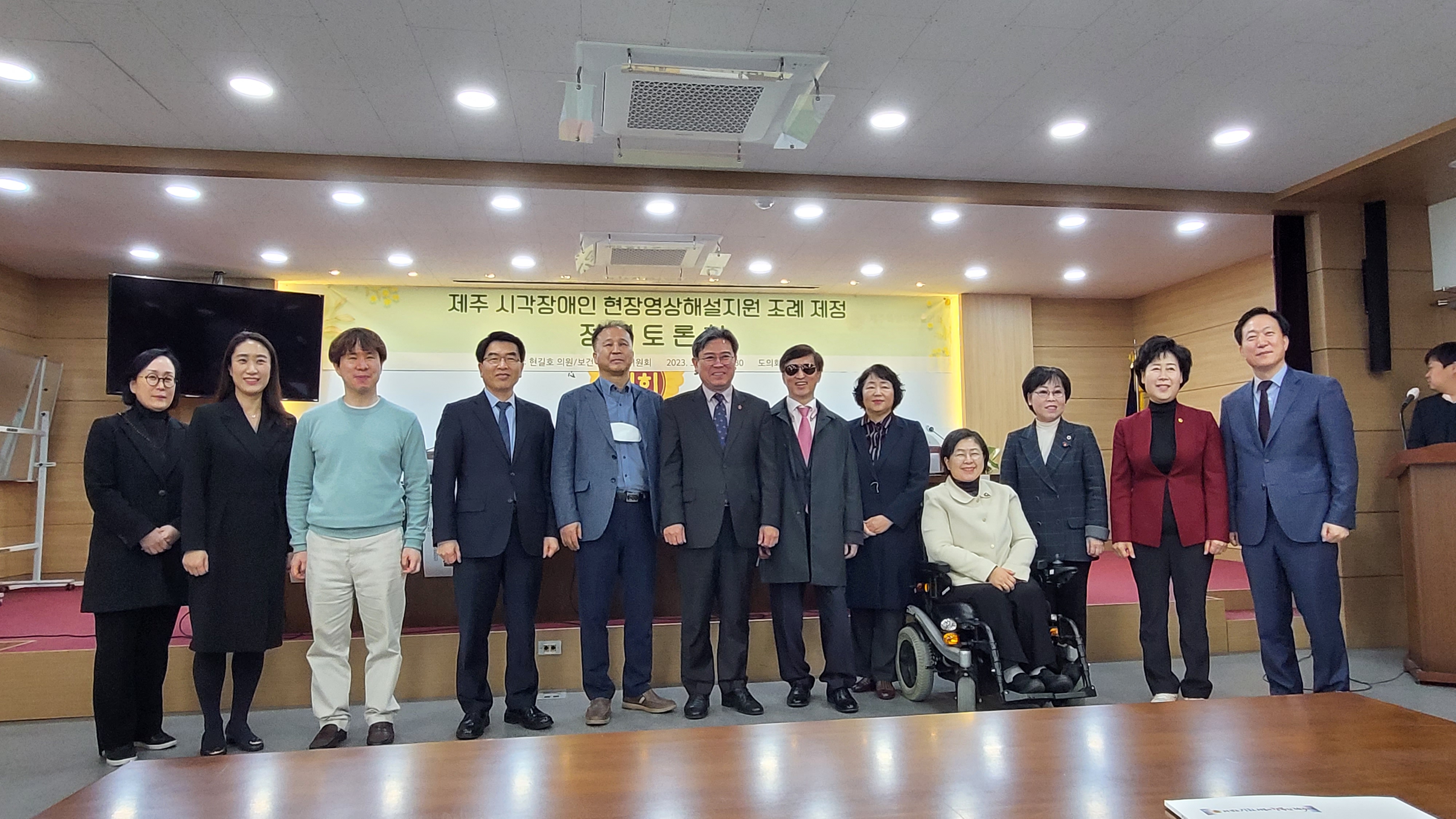 제주도의회 의원들과 토론자들 12명이 현수막 앞에 서서 찍은 단체사진.jpg